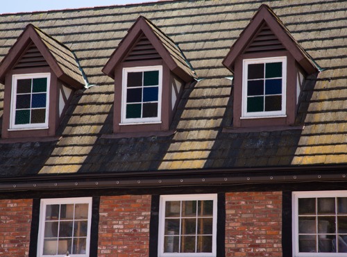 An intricately roofed building is seen. Popejoy Roofing recommends Malarkey Shingles in Mahomet IL.