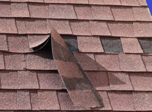 A damaged roof is seen. If you're wondering, "What do shingles falling off my roof mean?" call Popejoy Roofing in Bloomington/Normal and Champaign/Urbana.