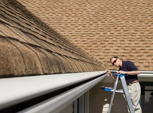 A man is seen checking out a roof. For Roofing Services in Champaign IL call Popejoy Roofing.