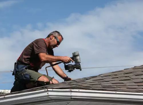 A roofer is seen working on a roof. For Roofing Services in Champaign IL call Popejoy Roofing.